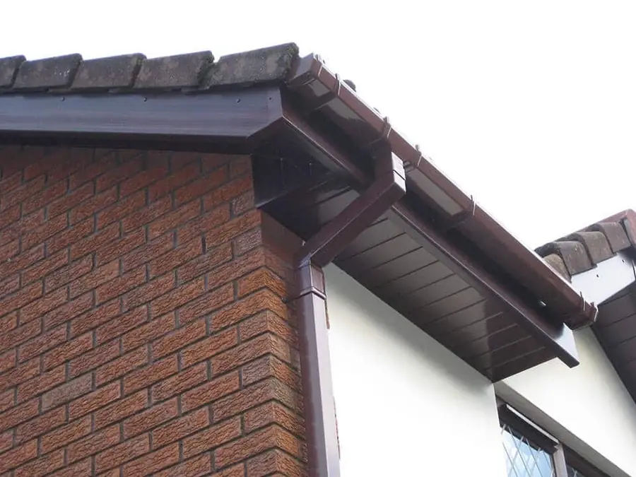 Brown fascia, soffit, gutter and downpipe on a brick and rendered house