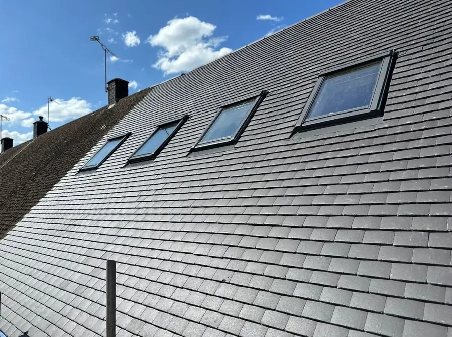 Grey slate roof with four roof windows in a row
