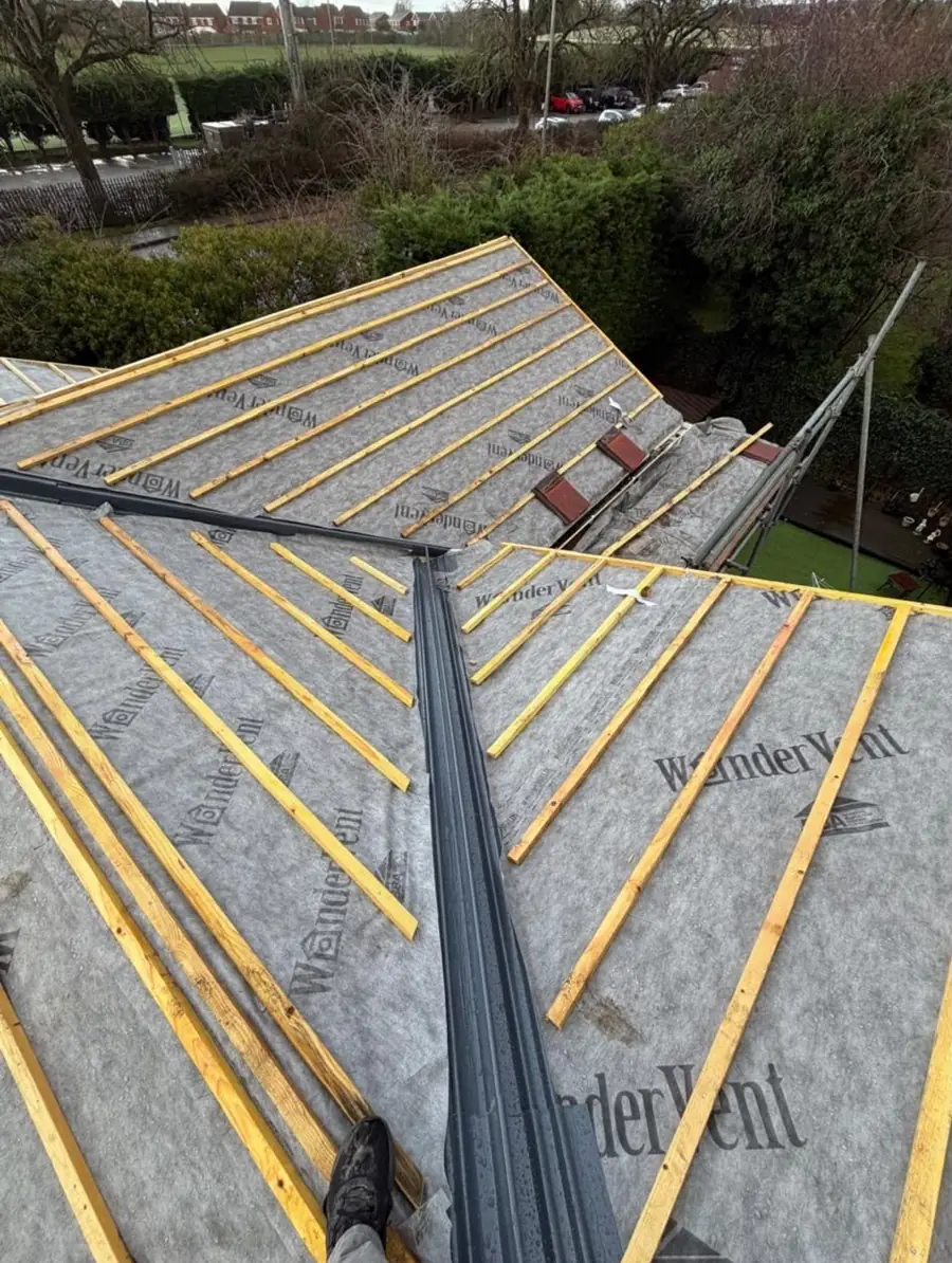 Membrane and yellow battens either side of a valley gutter trough, seen from the roof