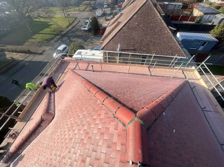 Red tiled hip roof with finished ridges seen from above, edge protection round the eaves
