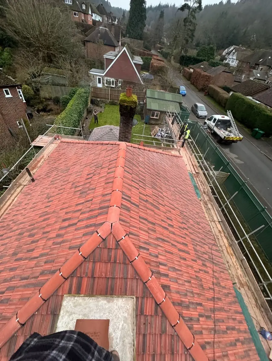 Red tiled hip roof with a finished ridge seen from above, gardens and a road below