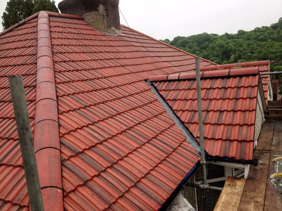 Red tiled roof with a ridge and a small dormer, scaffold at the eaves
