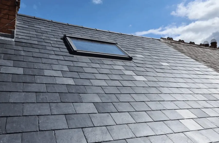 Finished slate roof with a roof window and a chimney