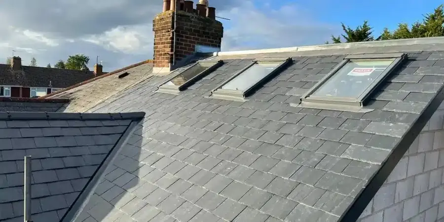 Slate roof with three roof windows, a chimney and lead flashing