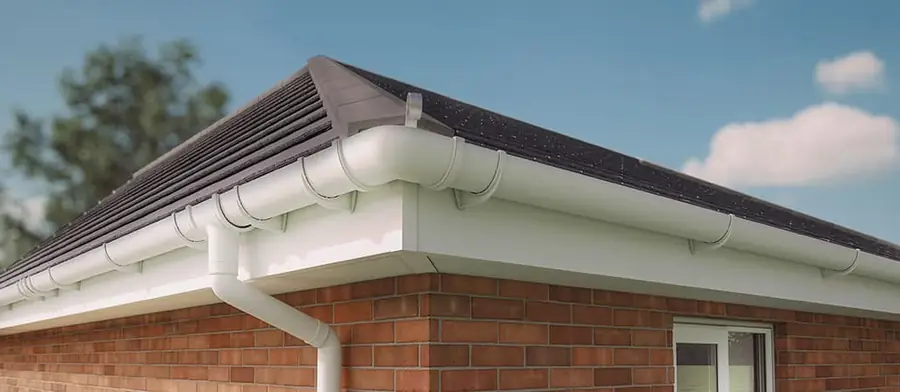 White fascia, soffit and gutter with a downpipe under a dark tiled hip roof